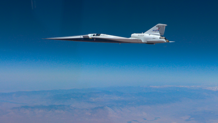 NASA’s X-59 quiet supersonic research aircraft flies above the clouds during its first supersonic flight. The aircraft is shown in side profile during level flight with desert and mountain terrain visible below.