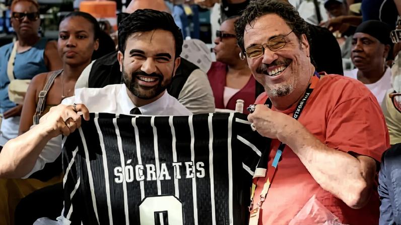 O prefeito de Nova York, Zohran Mamdani, recebe uma camisa do Corinthians do comentarista e ex-jogador Walter Casagrande durante a Copa do Mundo 2026, nos EUA (Alexandre Battibugli/VEJA)