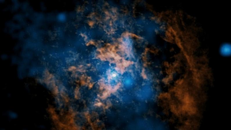 Nuvens difusas de gás em tons de azul e laranja se misturam formando uma estrutura irregular contra fundo preto. O ponto branco no centro é Sagitário A*; laranja representa dados dos radiotelescópios Alma no Chile para gás frio; azul refere-se aos dados do Observatório de Raios X Chandra, da Nasa, indicando uma cavidade que pesquisadores dizem ter sido criada por um vento quente e energético proveniente do buraco negro