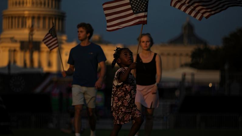 Criança levanta bandeira dos EUA em meio à Grande Feira Estadual Americana, em Washington, em meio as celebrações dos 250 anos da Independência americana