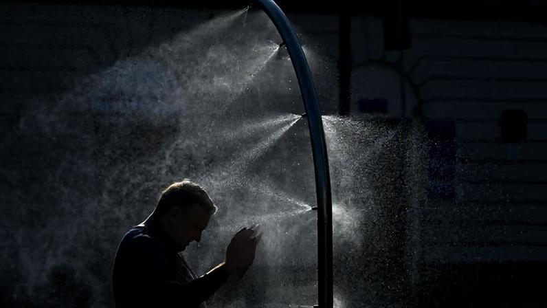 Homem tenta se refrescar em Varsóvia, na Polônia, em meio a onda de calor, no último dia 29