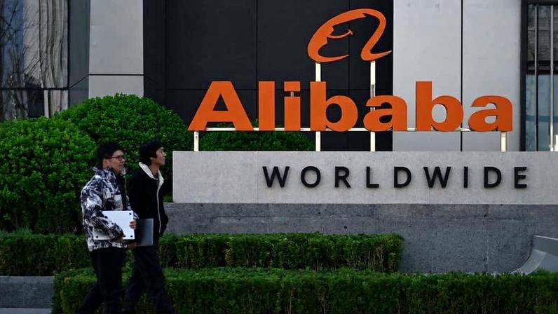 Funcionários caminham em frente à sede da Alibaba, em Pequim