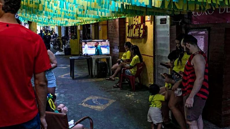 Famílias da favela da Rocinha, no Rio, assistem à partida entre Brasil e Japão pela Copa do Mundo, na última segunda-feira (29)