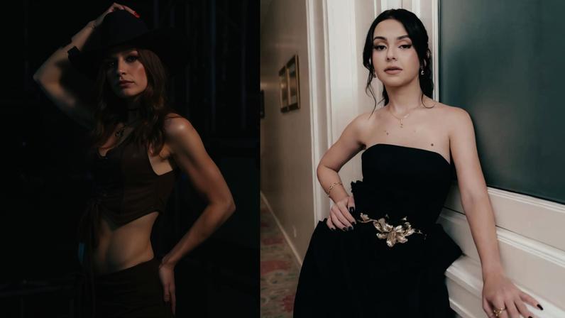 À esquerda, mulher com cabelo longo e ruivo usa chapéu preto e conjunto marrom com top cropped e saia, posando com mão na cabeça. À direita, mulher de cabelo preto preso veste vestido preto tomara que caia com detalhe dourado na cintura, apoiada em parede branca.