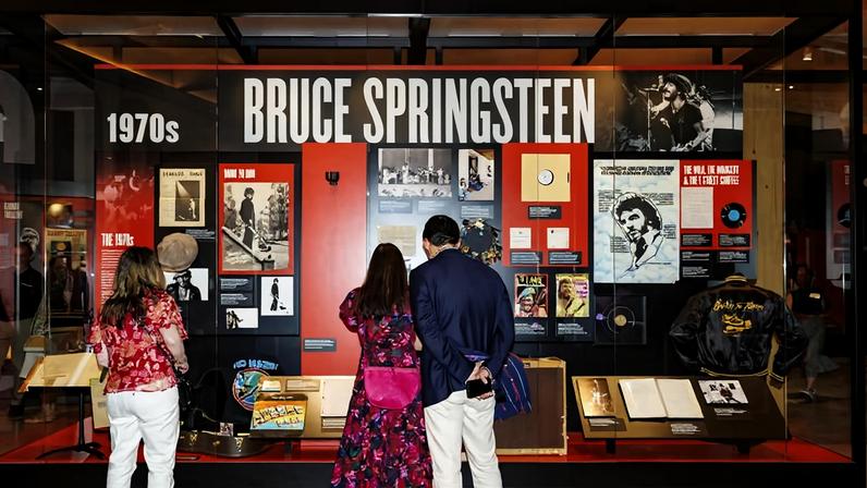 Visitantes observam uma exposição sobre Bruce Springsteen nos anos 1970 no Centro Bruce Springsteen de Música Americana