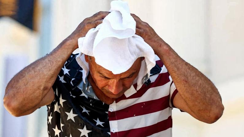 Um homem se refresca com uma toalha durante a Great American State Fair em Washington, Estados Unidos, marcando as comemorações do 4 de Julho
