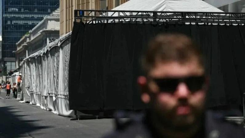 Um policial de Nova York faz a segurança enquanto equipes finalizam os ajustes em uma tenda instalada em frente ao Madison Square Garden, em 3 de julho de 2026