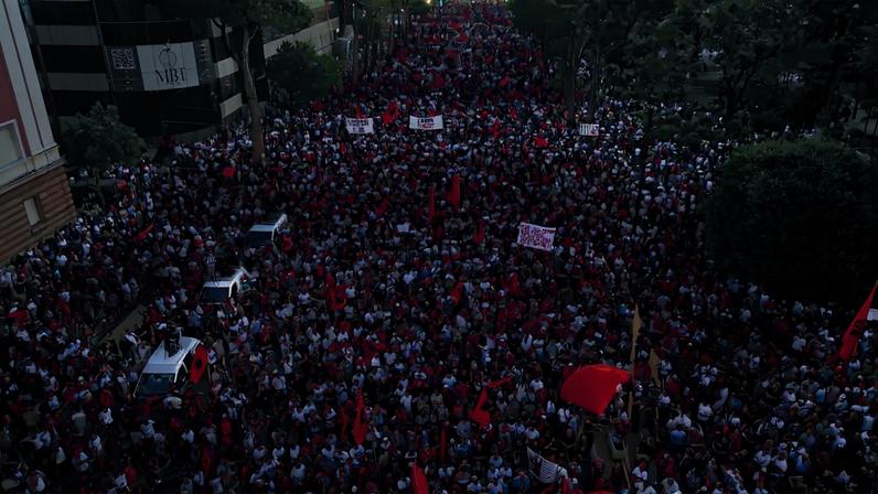 Imagens aéreas captadas por drone mostram manifestantes agitando bandeiras nacionais albanesas em protesto contra o governo, após semanas de manifestações contra um resort de luxo planejado por uma empresa ligada a Jared Kushner, genro do presidente dos EUA, Donald Trump, em uma área ambientalmente sensível da costa do Adriático, em Tirana, Albânia, 4 de julho de 2026. REUTERS/Florion Goga