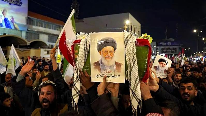 Procissão simbólica noturna no Irã, com a multidão carregando bandeiras e fotos do ex-líder supremo do Irã, o aiatolá Ali Khamenei