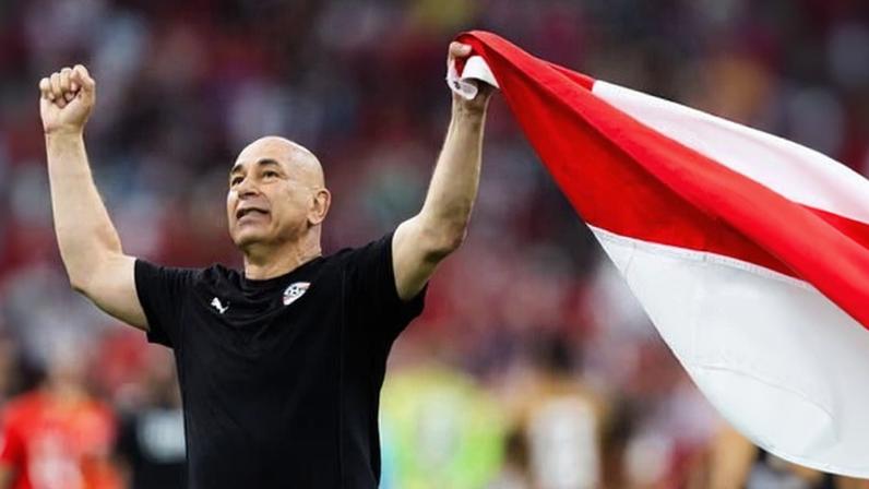 Egypt head coach Hossam Hassan holds up the Egyptian flag in celebration after the World Cup 2026 group game victory over New Zealand.