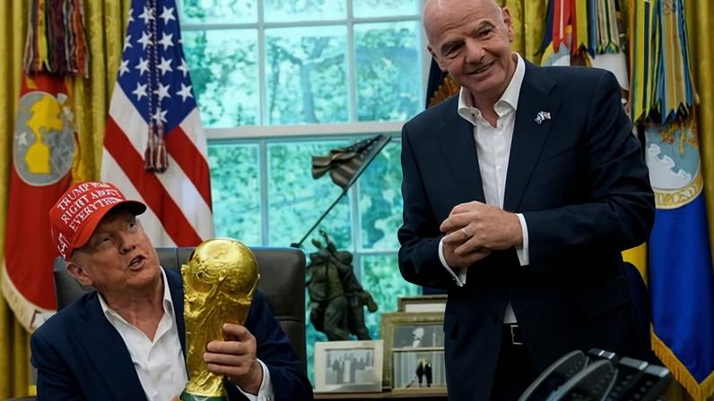 Donald Trump holds a trophy in the Oval Office next to Fifa president Gianni Infantino last year.