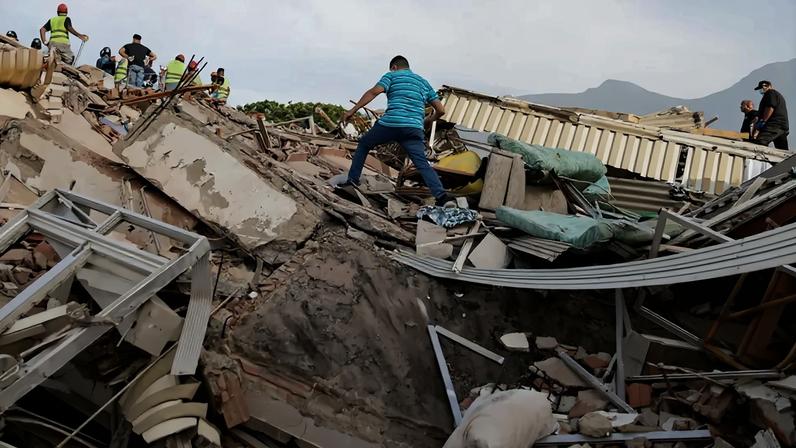 Um voluntário caminha sobre os escombros de um prédio desabado após os dois terremotos em Caraballeda, no estado de La Guaira, na Venezuela, em 25 de junho. Fotógrafo: Donaldo Barros/AFP/Getty Images/via Bloomberg