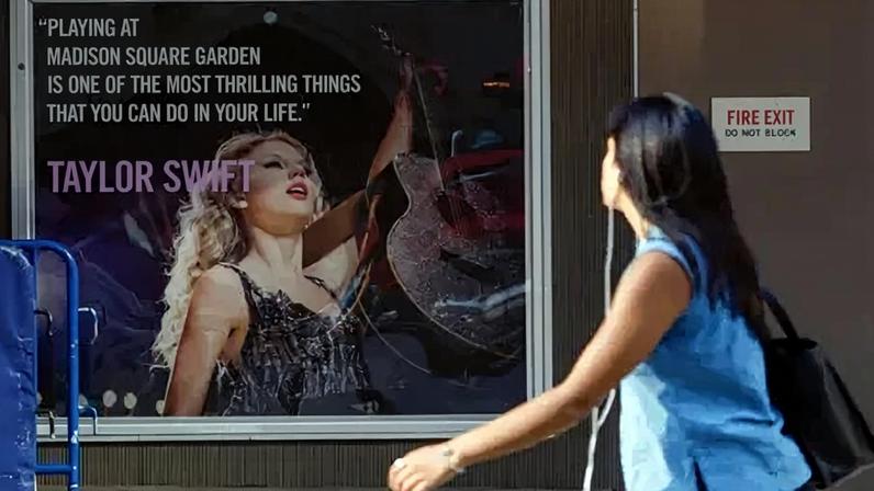 Getty Images A person walks by a poster featuring an image and quote from US singer-songwriter Taylor Swift outside Madison Square Garden in New York on July 1, 2026.