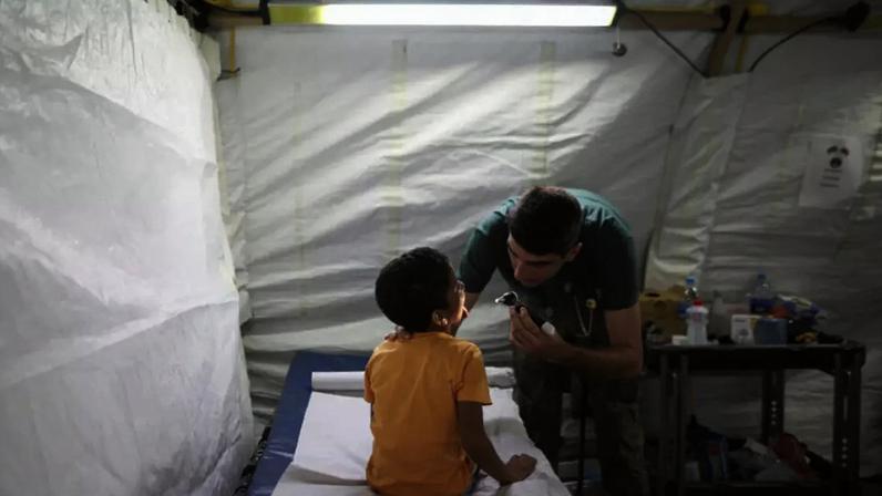 Criança sobrevivente é examinada em hospital de campanha em La Guaira. (02/07/2026)