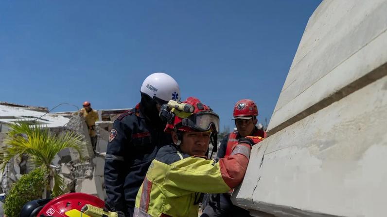 Firefighters and international rescuers search the remains of a collapsed building in La Guaira, Venezuela.