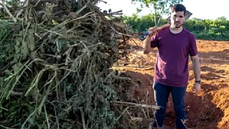 André Fernandes com uma pá em local onde os pés de maconha estavam enterrados