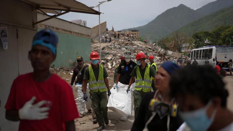 Resgatistas carregam corpo de vítima de terremoto na Venezuela; estimativas apontam quase 3 mil mortos.