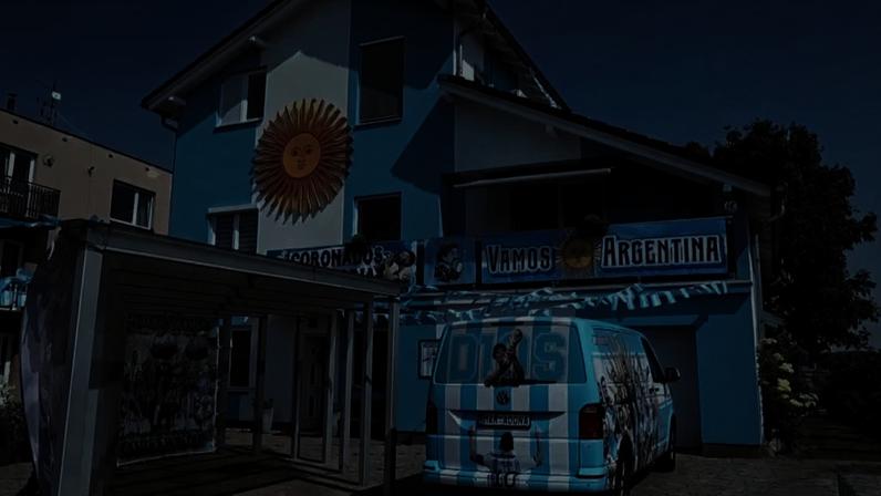 Casa de dois andares, pintada em azul e branco, as cores da bandeira da Argentina, decorada com símbolos e frases.