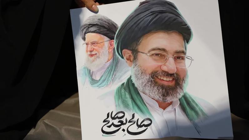 Mulher segura imagem do novo líder supremo do Ira Mojtaba Khamenei e do líder anterior, o aiatola Ali Khamenei, durante cerimônia fúnebre para comandantes militares iranianos.