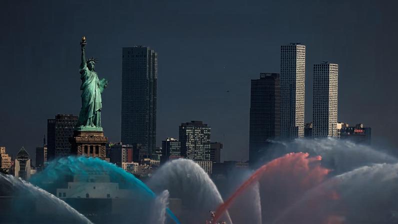 Embarcação do Corpo de Bombeiros de Nova York lança jatos de água no encontro de veleiros e navios militares em homenagem ao 250º aniversário dos Estados Unidos.