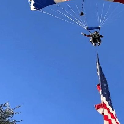 Paraquedista com bandeira gigante dos EUA fica preso em árvore e cai sobre tenda