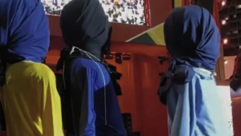 Bonecos gigantes dos jogadores da Seleção deixando a festa com as cabeças cobertas