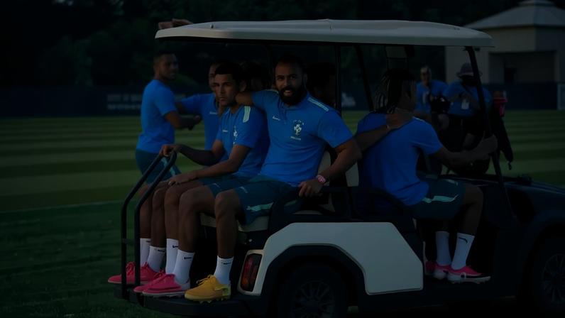 Jogadores da seleção se aglomeram e pegam carona em carrinho de golfe no treino