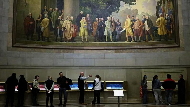 Visitantes passam diante de um mural que retrata a assinatura da Declaração de Independência, no Arquivo Nacional, em Washington: oposição acusa instrumentalização política da data — Foto: John McDonnell/AP