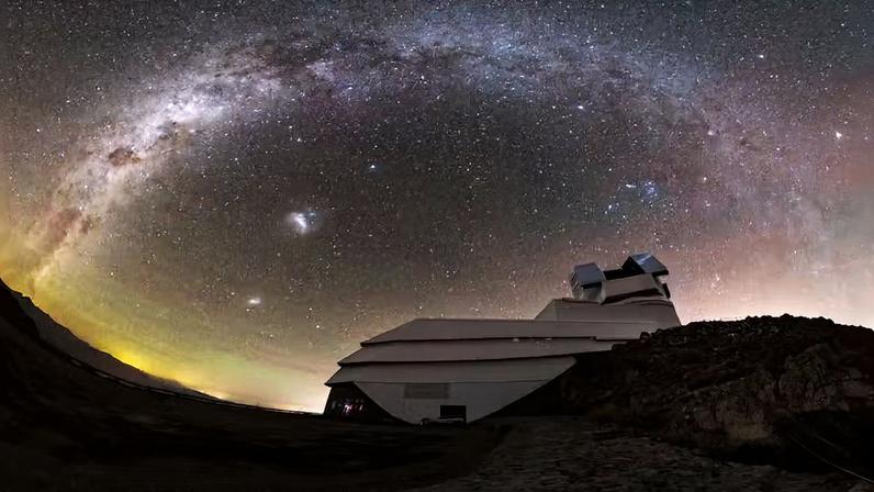 Nesta foto capturada em fevereiro de 2026, o Observatório Rubin da NSF-DOE observa o céu noturno chileno acima do Cerro Pachón, sob a vista deslumbrante da nossa galáxia, a Via Láctea, e suas maiores galáxias companheiras, as Nuvens de Magalhães Grande e Pequena