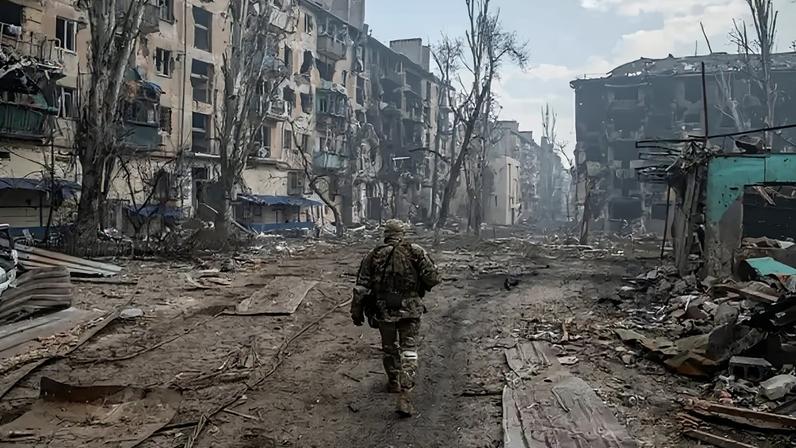 Soldado russo caminhando entre destroços após ataque à cidade ucraniana de Mariupol. 15/04/2024