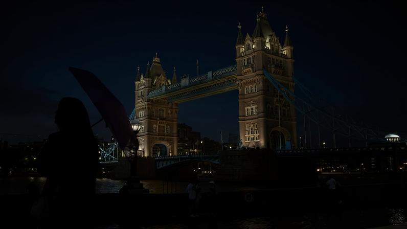 Mulher usa sombrinha para se proteger do calor extremo em Londres, na Inglaterra