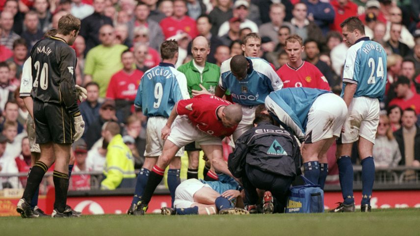 Roy Keane tira satisfações com Alf Inge Haaland caído no gramado — Foto: Gary M Prior/Allsport