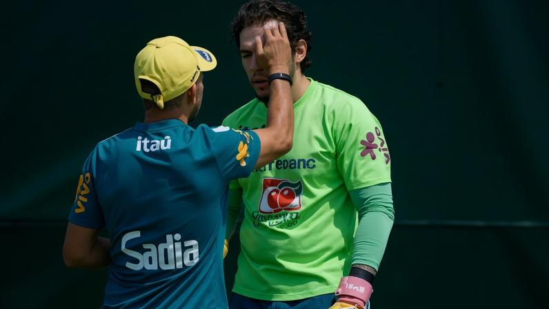 Goleiro Ederson passa protetor solar diante do sol forte em treino da seleção brasileira