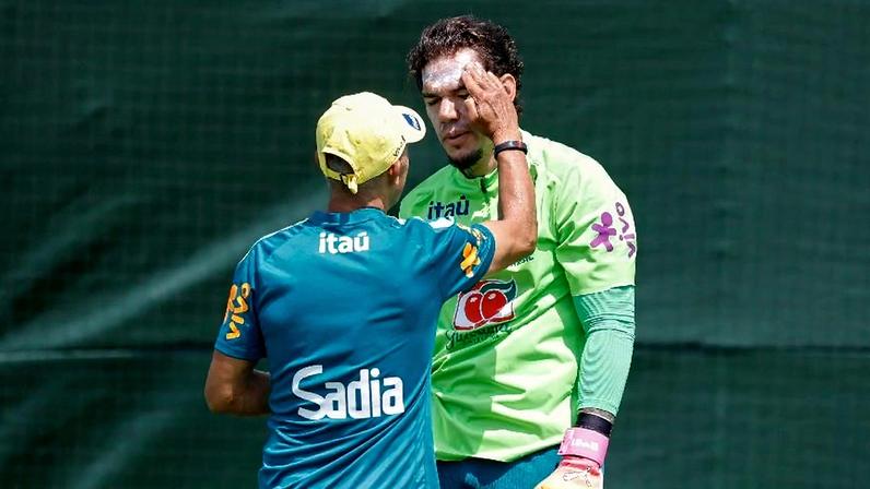 Goleiro Ederson passa protetor solar diante do sol forte em treino da seleção brasileira