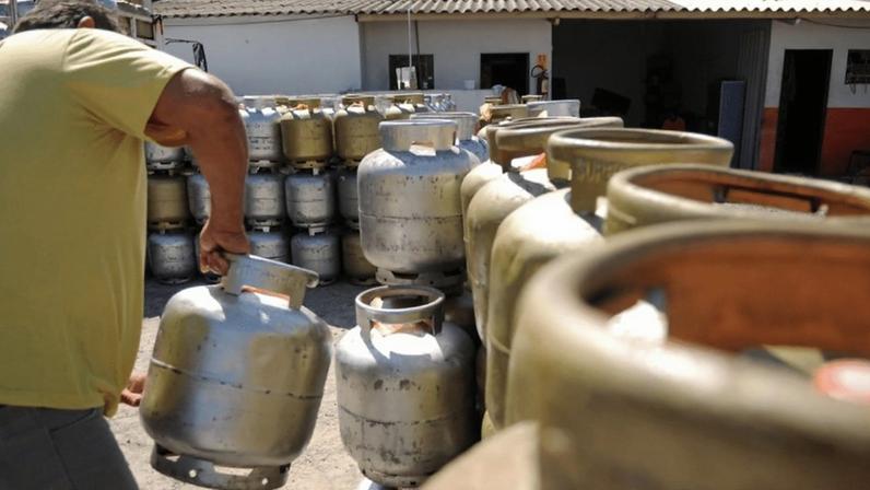Homem carrega botijão de gás de cozinha