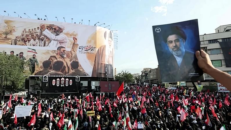 Um participante do funeral segura uma foto do Líder Supremo Mojtaba Khamenei durante o cortejo fúnebre do falecido Aiatolá Ali Khamenei em Teerã, Irã, na segunda-feira