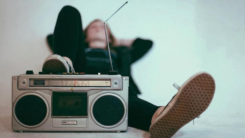 Imagem colorida mostra mulher escutando musica - Metrópoles