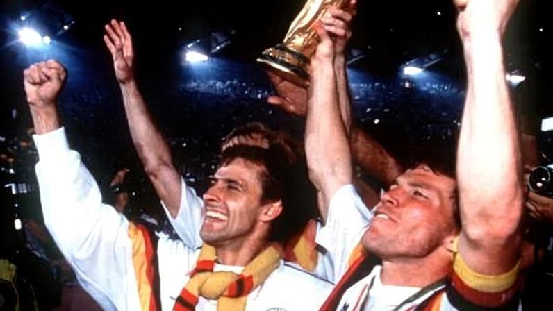 Pierre Littbarski (à esquerda) e Lothar Matthaus (à direita), da Alemanha Ocidental, levantam a taça da Copa do Mundo de 1990