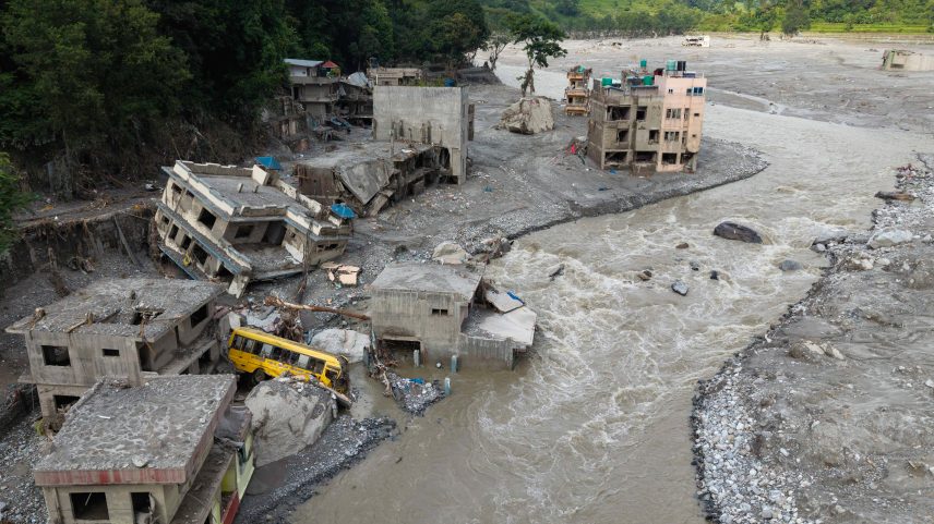 Imagem aérea mostra torrente de água barrenta avançando por casas e pelo rio Trishuli após as enchentes repentinas, em Betrawati, no distrito de Nuwakot, no Nepal, em 29 de agosto de 2026 | Foto: Prabin Ranabhat/AFP