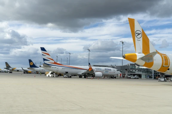 Aviões de diferentes companhias aéreas estacionados no pátio do Aeroporto de Leipzig/Halle, sob céu nublado