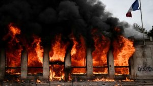 Posto de informações turísticas é tomado pelas chamas após ser incendiado por manifestantes durante protestos contra o custo de vida em Lyon, na França, neste sábado (17)