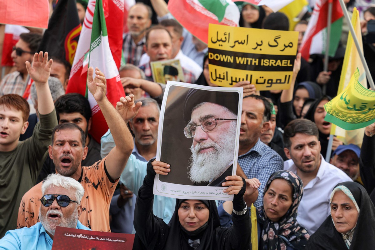 Manifestante levanta foto do líder supremo do Irã, Ali Khamenei, durante protesto em solidariedade ao regime em Teerã (Foto: ATTA KENARE / AFP)