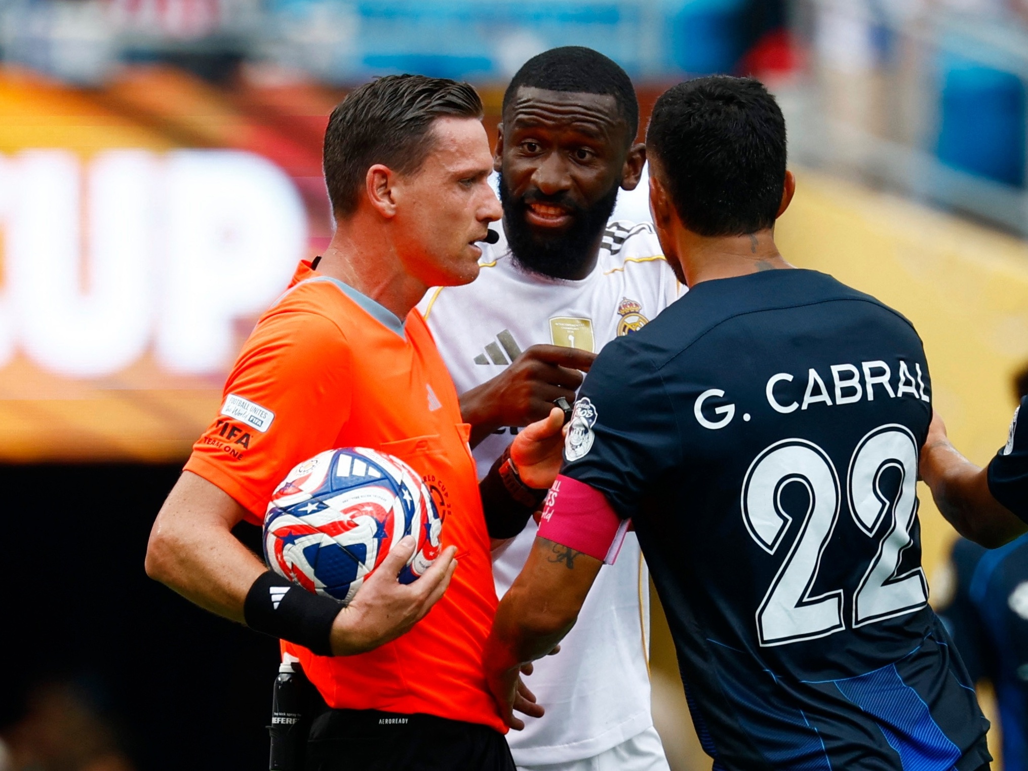 Árbitros brasileiros se destacam no exterior enquanto enfrentam críticas no país Rüdiger, zagueiro do Real, conversa com árbitro Ramon Abatti Abel durante jogo no Mundial (Foto: Susana Vera/REUTERS)