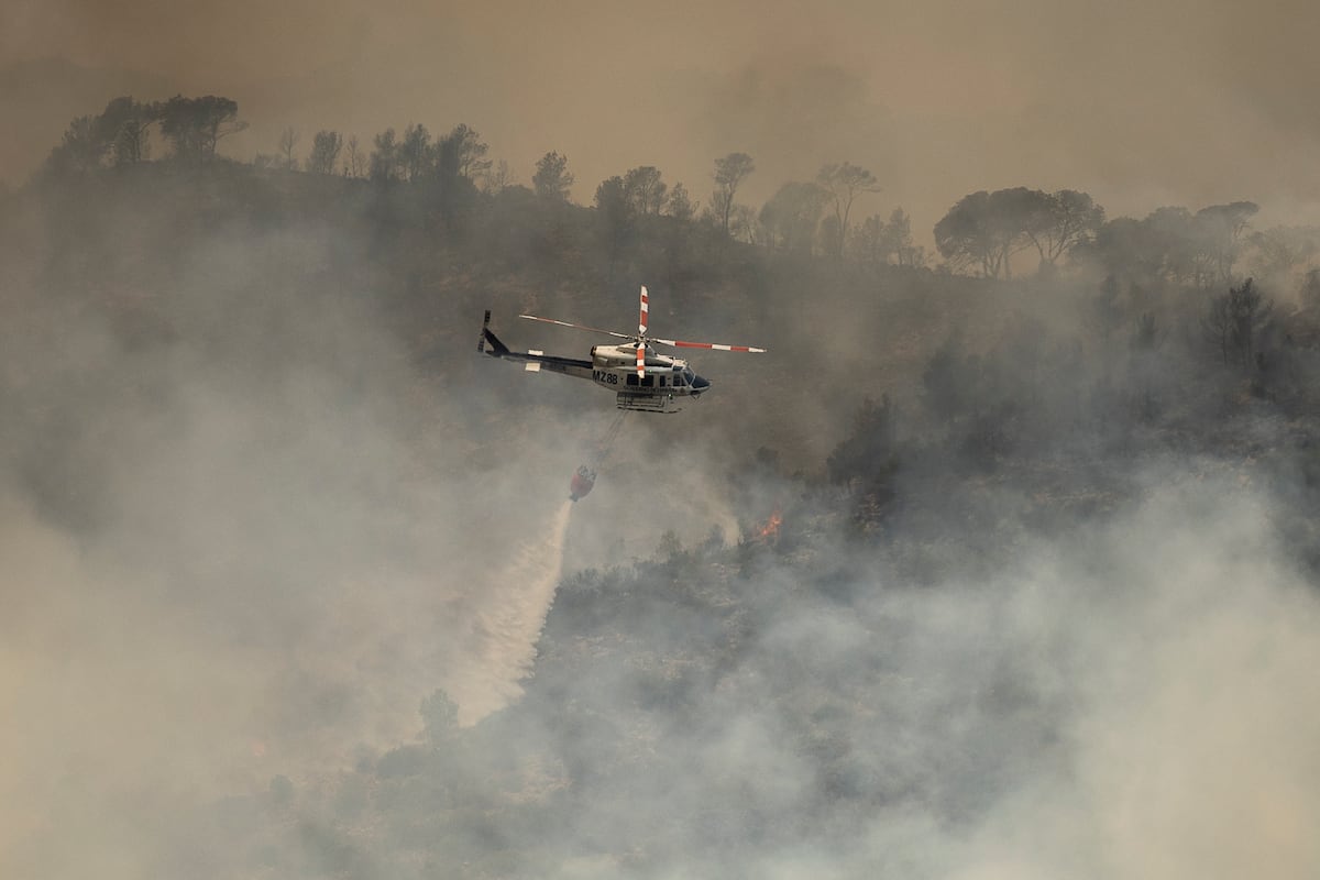 Um helicóptero lança água no incêndio. (Foto: Albert Garcia)