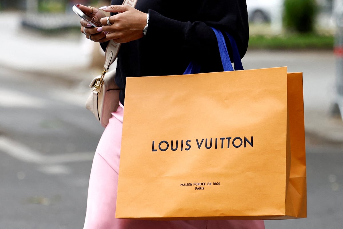 Uma mulher caminha com uma bolsa de compras da Louis Vuitton em Paris. (Foto: Abdul Saboor/REUTERS)