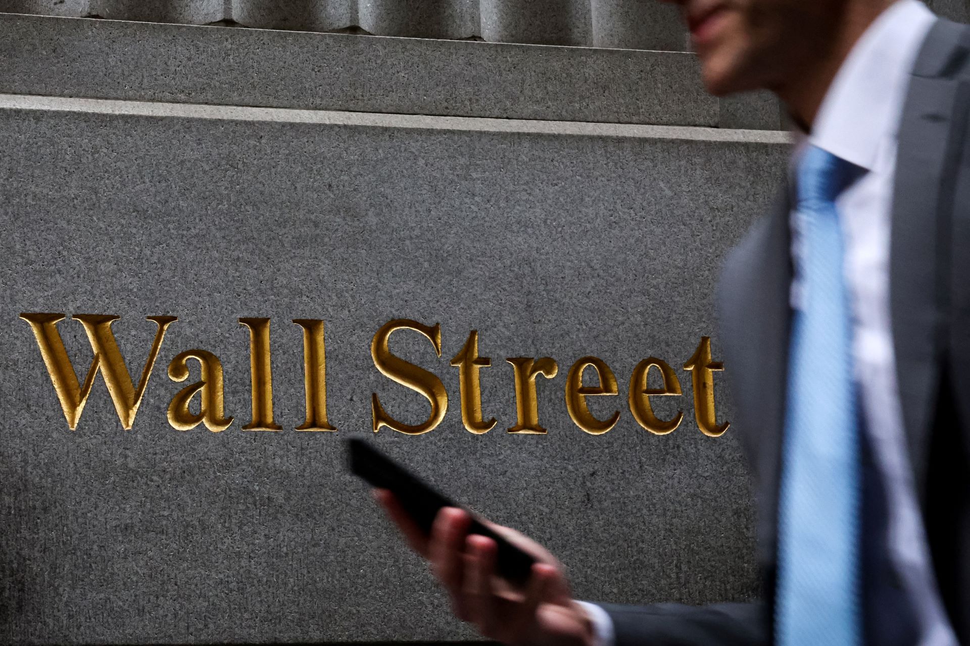 Homem caminha na Wall St. do lado de fora da Bolsa de Nova York - 07/04/2025 (Foto: REUTERS/Brendan McDermid)