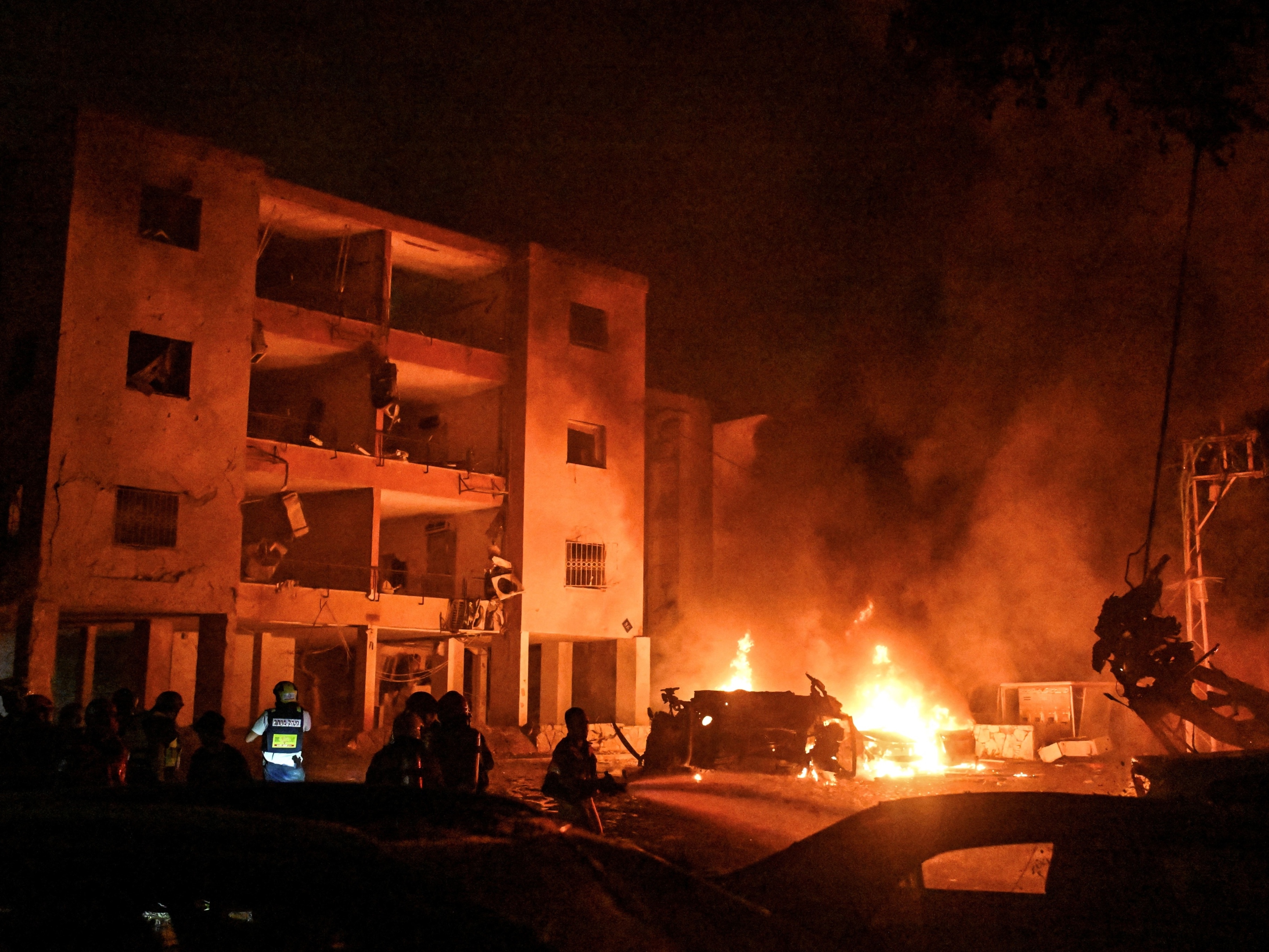 Guerra entre Israel e Irã completa oito dias e tensão continua a crescer Bombeiros e equipes de resgate trabalham em um local atingido por um ataque de mísseis do Irã contra Israel, em Haifa (Foto: Rami Shlush/Reuters)
