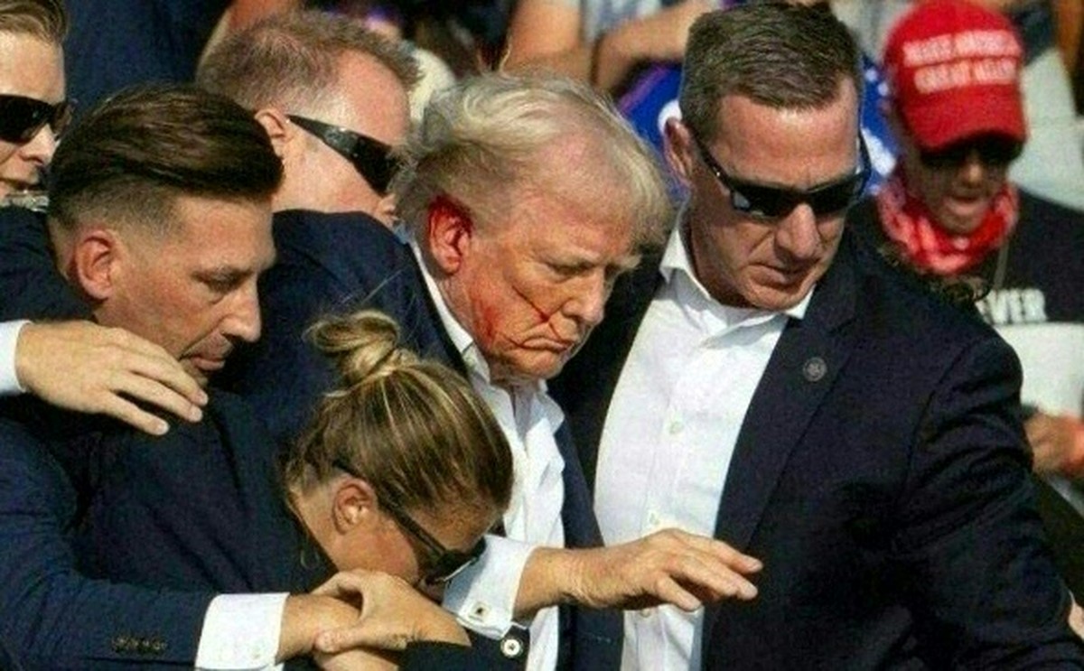 Trump reconhece erros do Serviço Secreto após tentativa de assassinato há um ano Donald Trump é retirado de palco de comício, sangrando, por agentes do serviço secreto dos EUA (Foto: Rebecca Droke/AFP)