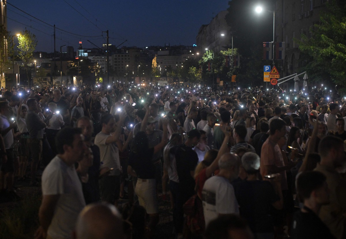 Milhares de pessoas protestam e bloqueiam estradas em noite de agitação na Sérvia Manifestantes protestam em frente ao Ministério Público, pedindo a libertação de cidadãos detidos em protestos na noite de sábado, em Belgrado (Foto: OLIVER BUNIC / AFP)