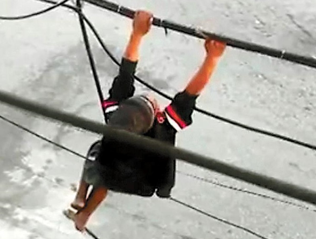 Mortes em roubos de cabos elétricos disparam mais de 200% em dez anos Homem se pendura em fiação para furtá-la: crime é motivado pelo valor do cobre, que se valorizou nesta década (Foto: Reprodução)